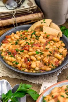 a bowl filled with beans and bread on top of a table