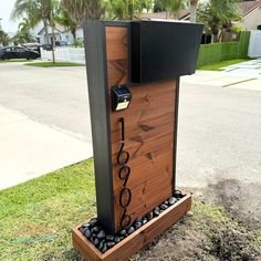 a wooden phone booth sitting on top of a grass covered field next to a street