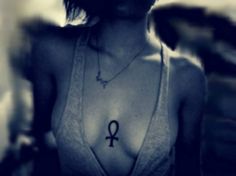 a woman wearing a bra with an egyptian symbol on it's chest and necklace