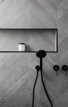 a shower head and hand held shower faucet in a bathroom with grey tile