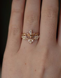 a woman's hand wearing a gold ring with diamonds on the middle and sides