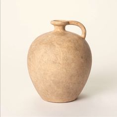 a brown vase sitting on top of a white table