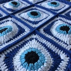 a blue and white crocheted blanket with eyeballs on it