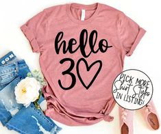 a pink shirt with the words hello 30 on it next to ripped jeans and flowers