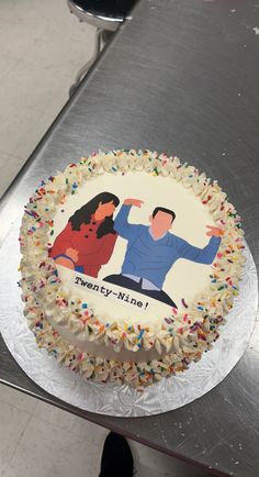 there is a cake with an image of two people on it and sprinkles