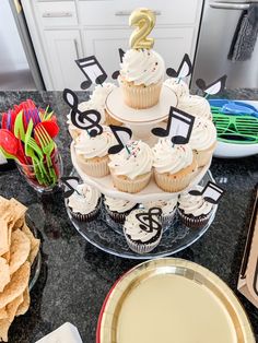 cupcakes are arranged on a cake stand with music notes and musical notes in the background