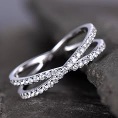 two white gold wedding bands on top of each other, with diamonds in the middle