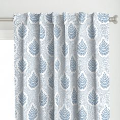 a blue and white patterned curtain hanging on a window