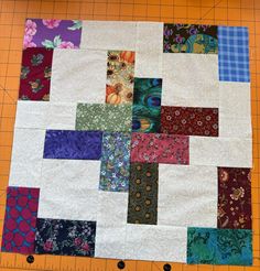 a piece of quilt is laying on top of a cutting board