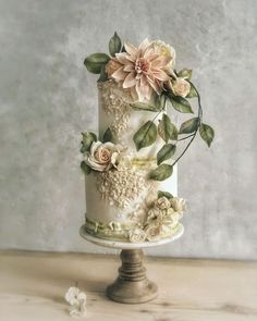 a wedding cake decorated with flowers and leaves