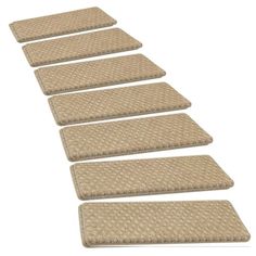 four beige rugs are lined up in a row on a white background with no people