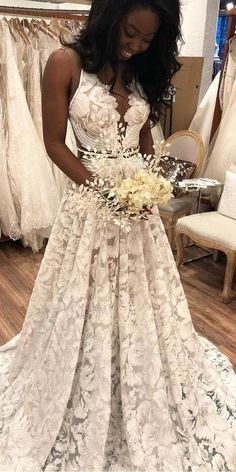 a woman standing in front of a wedding dress