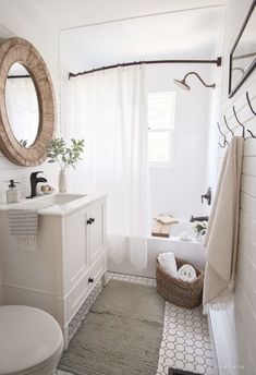 a bathroom with a toilet, sink, mirror and towel rack on the wall in it