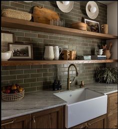 a kitchen sink sitting under a window next to wooden shelves