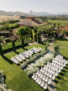 an aerial view of a wedding venue with rows of chairs set up in the grass