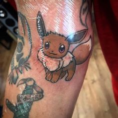 a person with a tattoo on their arm holding a knife in one hand and a small cartoon pikachu on the other