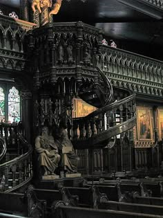 an ornate staircase with statues and paintings on the walls