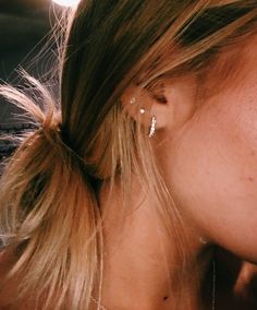 a close up of a woman's face with ear piercings