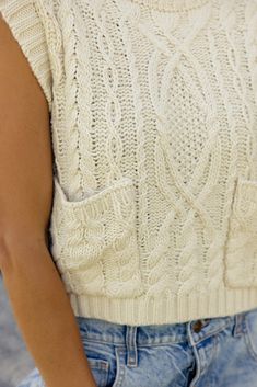 This chunky knit sweater vest is slightly cropped with front patch pockets. Pair the Organa Cable Knit Sweater Vest with jeans, over dresses, and layer it up this winter for a cute and cozy look. cropped front patch pockets // paired with the free people good luck mid rise barrel jeans in light-blue + slow morning club canvas trucker hat in black Fall Sweater Vest With Pockets For Layering, Fall Layering Sweater Vest With Pockets, Knit Sweater Vest With Pockets For Winter, Layering Sweater Vest With Pockets, Fall Sleeveless Sweater Vest With Pockets, Casual Sweater Vest With Pockets For Layering, Casual Sweater Vest With Pockets For Fall, Sleeveless Sweater Vest With Pockets For Layering, Casual Textured Knit Vest For Fall