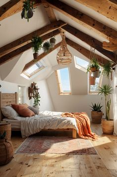 an attic bedroom with wooden floors and white walls, large bed surrounded by hanging plants