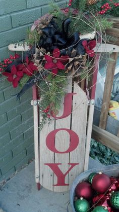 a wooden sign that says joy with ornaments around it