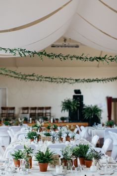 the tables are set with white linens and greenery