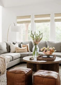 a living room filled with lots of furniture and flowers on top of a coffee table