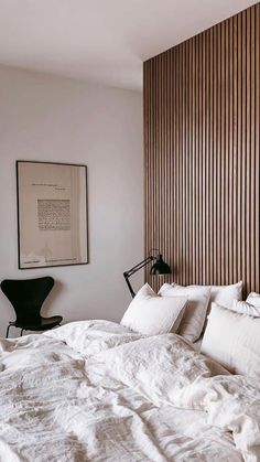 a bed with white linens and pillows in a bedroom next to a large window