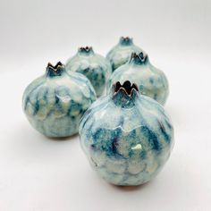 three blue vases sitting next to each other on a white surface