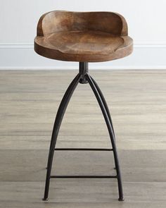 a wooden stool sitting on top of a hard wood floor next to a white wall