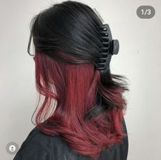 the back of a woman's head with red and black hair styled into a comb