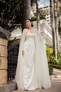 a woman in a white wedding gown with a long veil on her head and shoulders