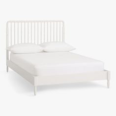 a white bed with two pillows on top of it