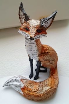 a paper sculpture of a fox sitting on top of a table