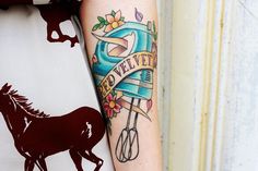 a tattoo on the arm of a woman with a horse and kitchen utensils