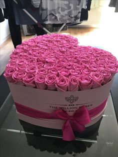 a large heart shaped box with pink roses in the shape of a heart on display