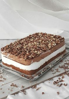 a cake that is sitting on top of a glass plate with chocolate shavings around it