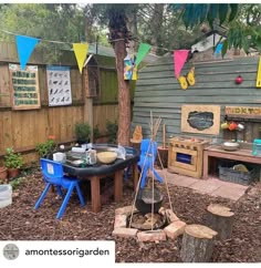 an outdoor kitchen is set up next to a tree in the yard with flags hanging above it