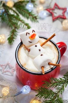 a cup filled with hot chocolate and marshmallows on top of a table