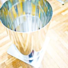 a metal cup sitting on top of a wooden table