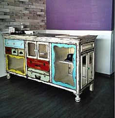 an old dresser painted with different colors and designs