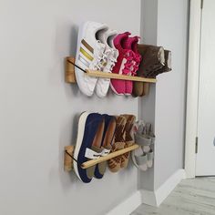 several pairs of shoes are hanging on the wall