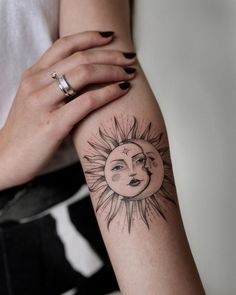 a woman's arm with a sun and moon tattoo on it