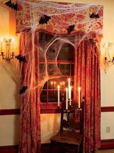 a room decorated for halloween with spider webs and candles