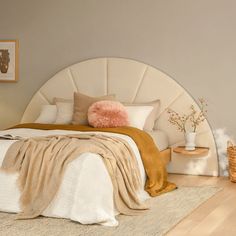 a bedroom with a bed, nightstands and pictures on the wall above it in neutral colors