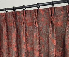 an orange and black curtain hanging from a metal rod