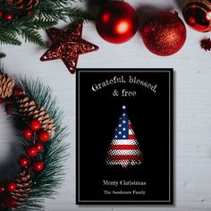 a christmas card with an american flag on it next to ornaments and pineconis