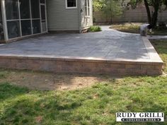 a large patio with steps leading up to the back door and an attached deck area