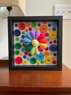 a wooden table topped with a frame filled with buttons