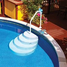 an above ground swimming pool with steps leading up to the water level and flowers growing on the deck